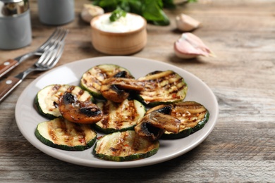 Photo of Grilled zucchini slices served on wooden table