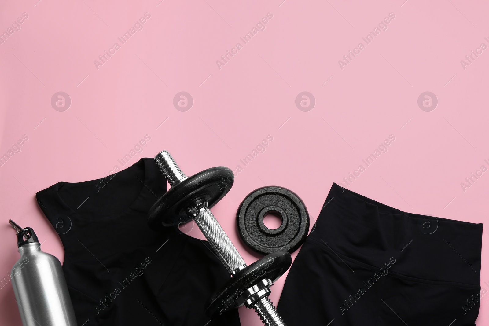 Photo of Sportswear, water bottle and dumbbell on pink background, flat lay with space for text. Gym workout