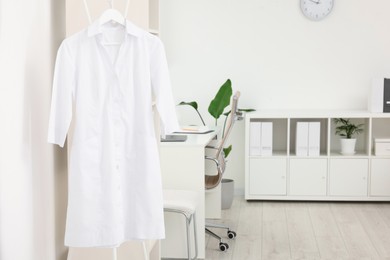 Photo of Doctor's gown on hanger near workplace in clinic