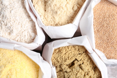 Paper bags with different types of flour, closeup