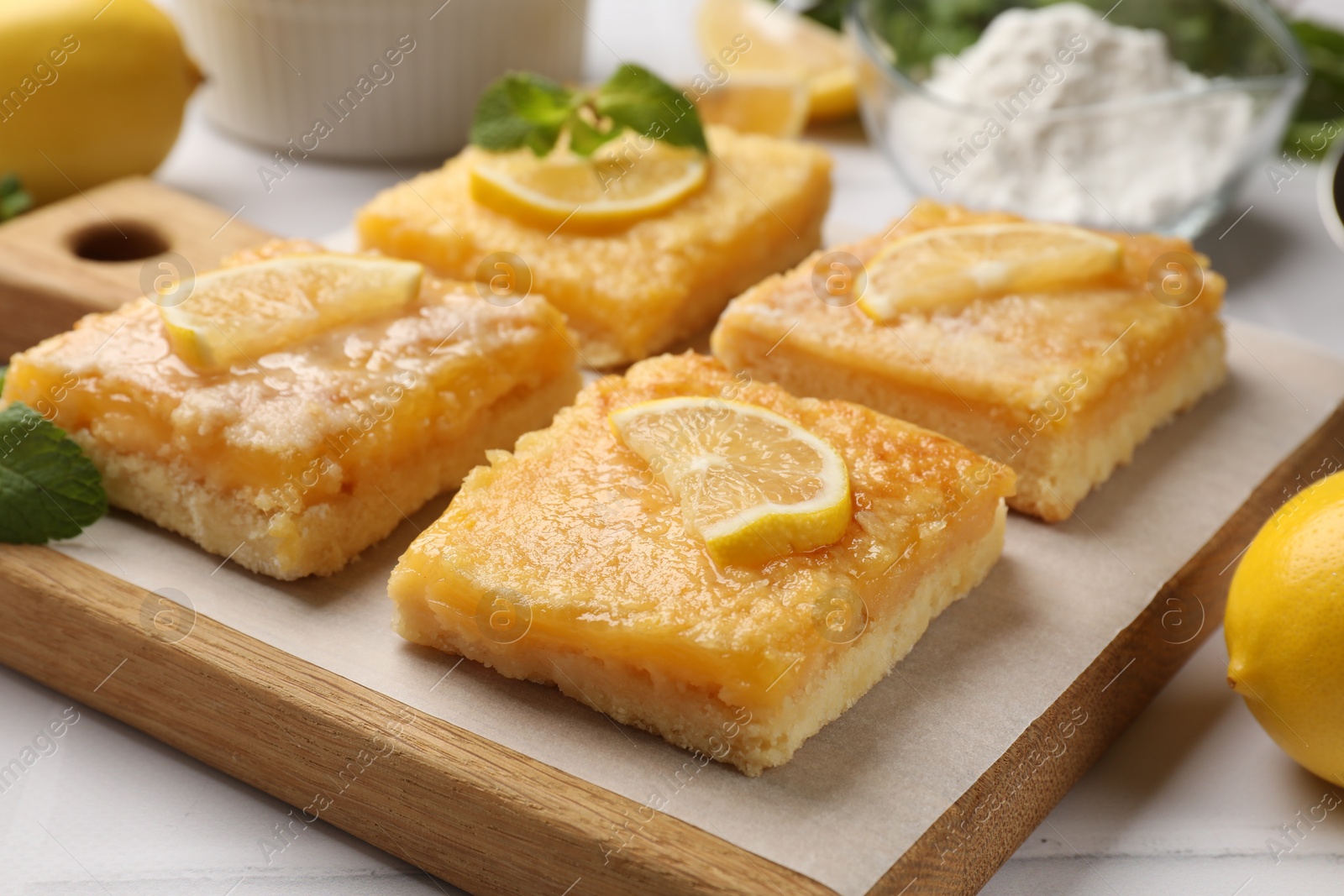 Photo of Tasty lemon bars on white table, closeup