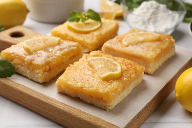 Photo of Tasty lemon bars on white table, closeup