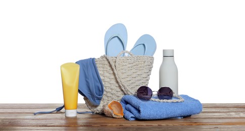 Stylish bag, sea shell and other beach accessories on wooden table against white background