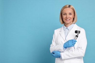 Happy dermatologist with dermatoscope on light blue background, space for text
