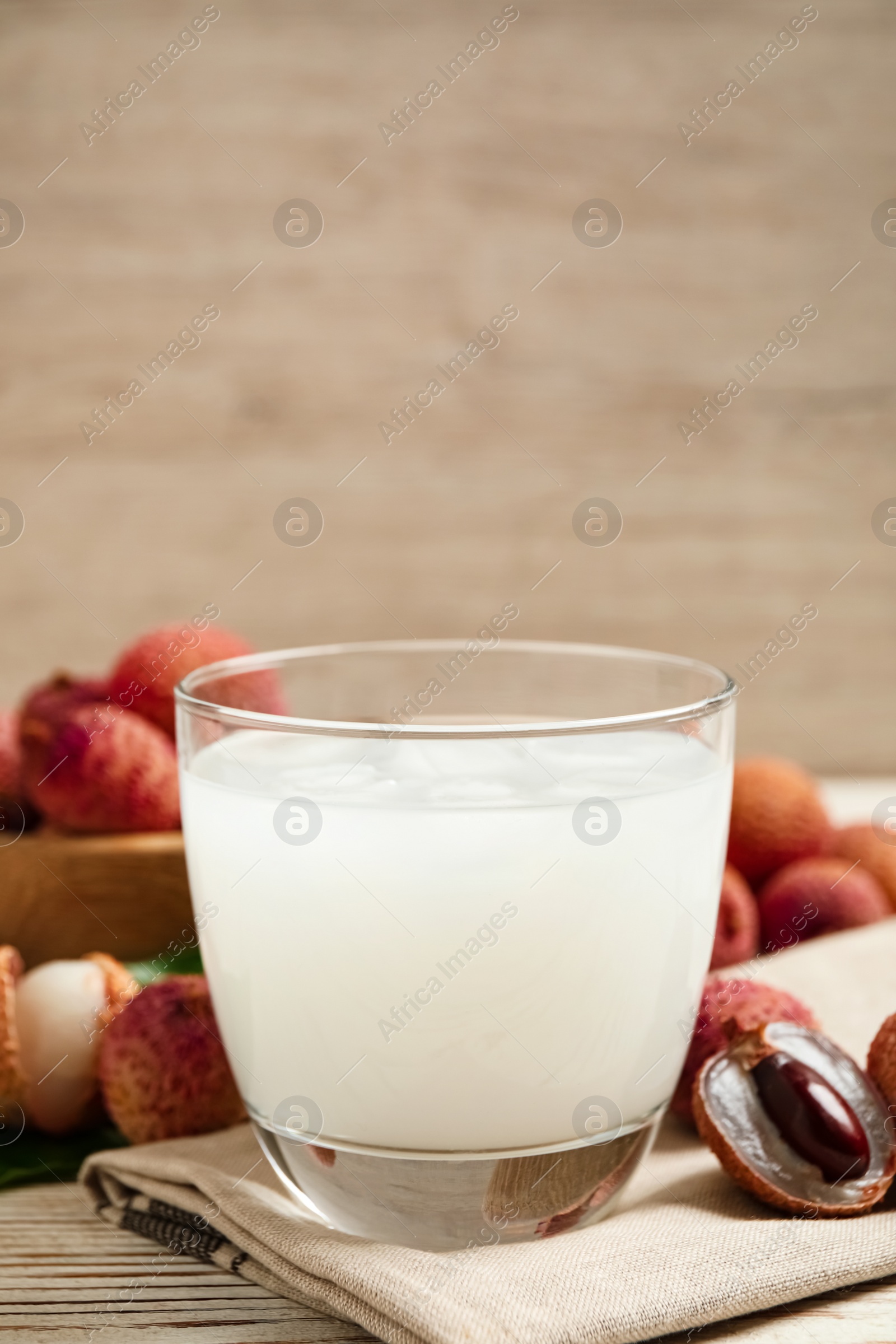 Photo of Fresh lychee juice and fruits on white wooden table