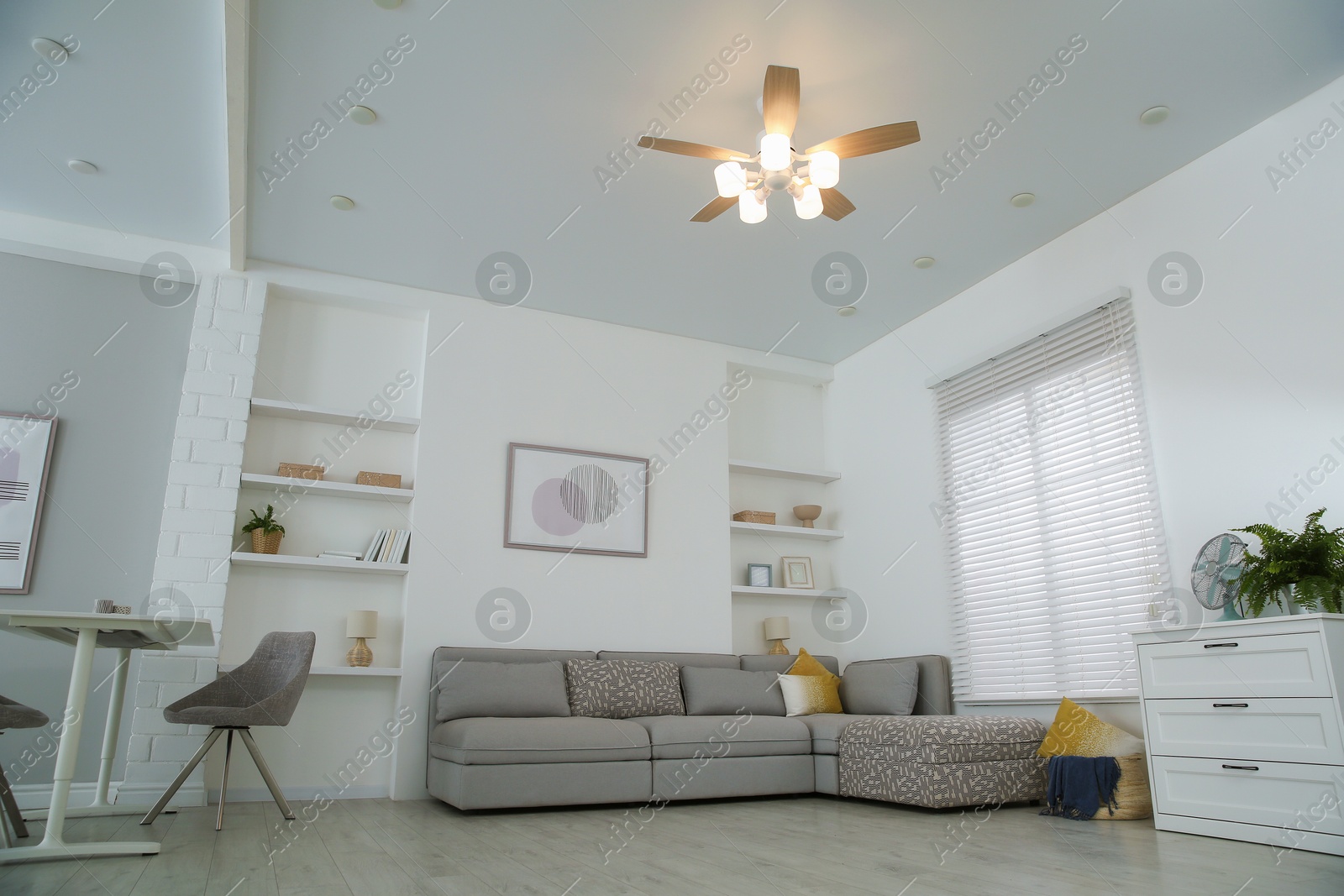 Photo of Comfortable furniture, ceiling fan and accessories in stylish living room