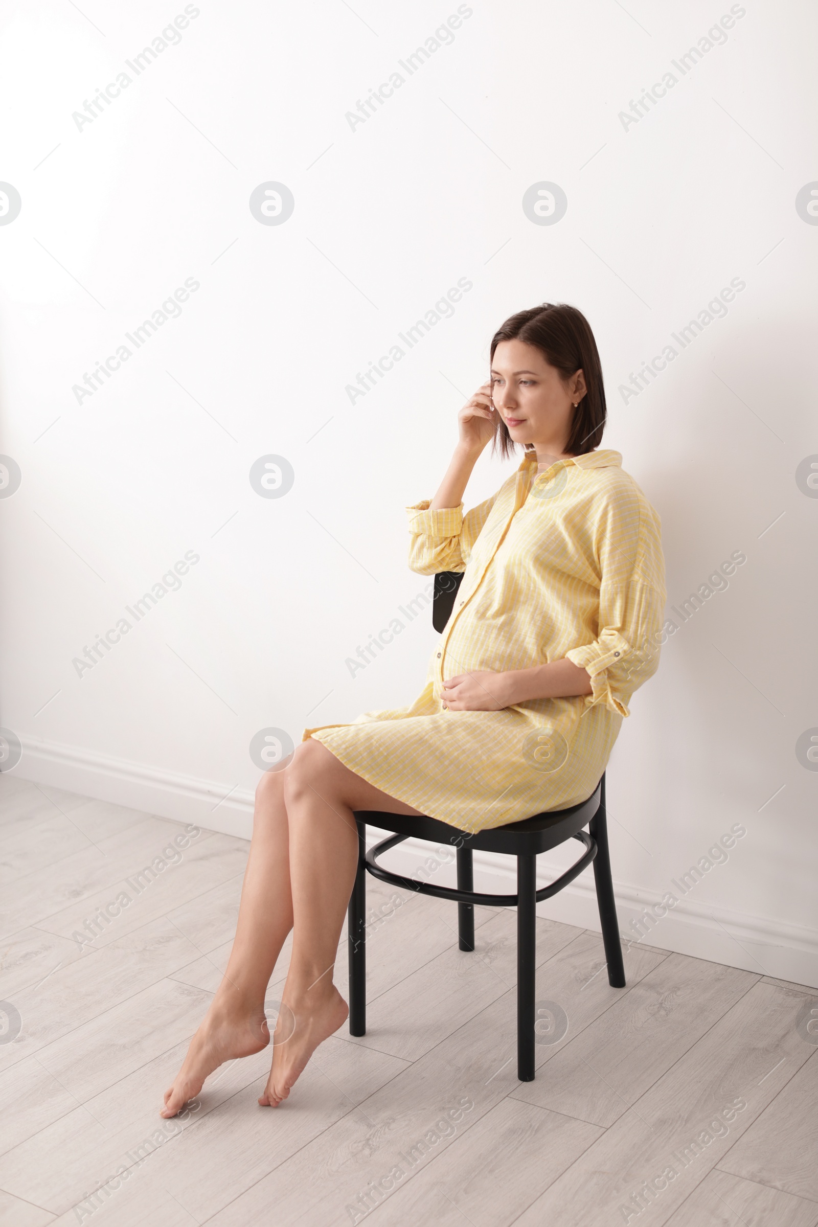 Photo of Beautiful pregnant woman sitting in light room