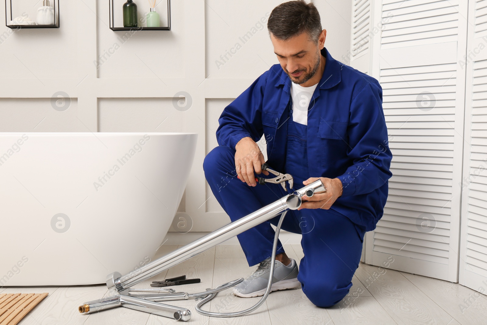 Photo of Professional plumber installing water tap in bathroom