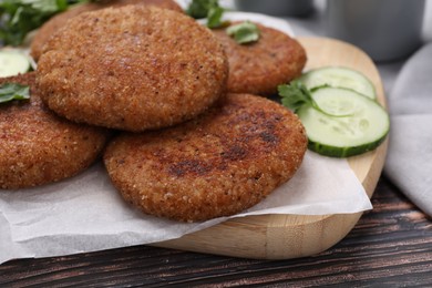 Tasty vegan cutlets served on wooden table, closeup