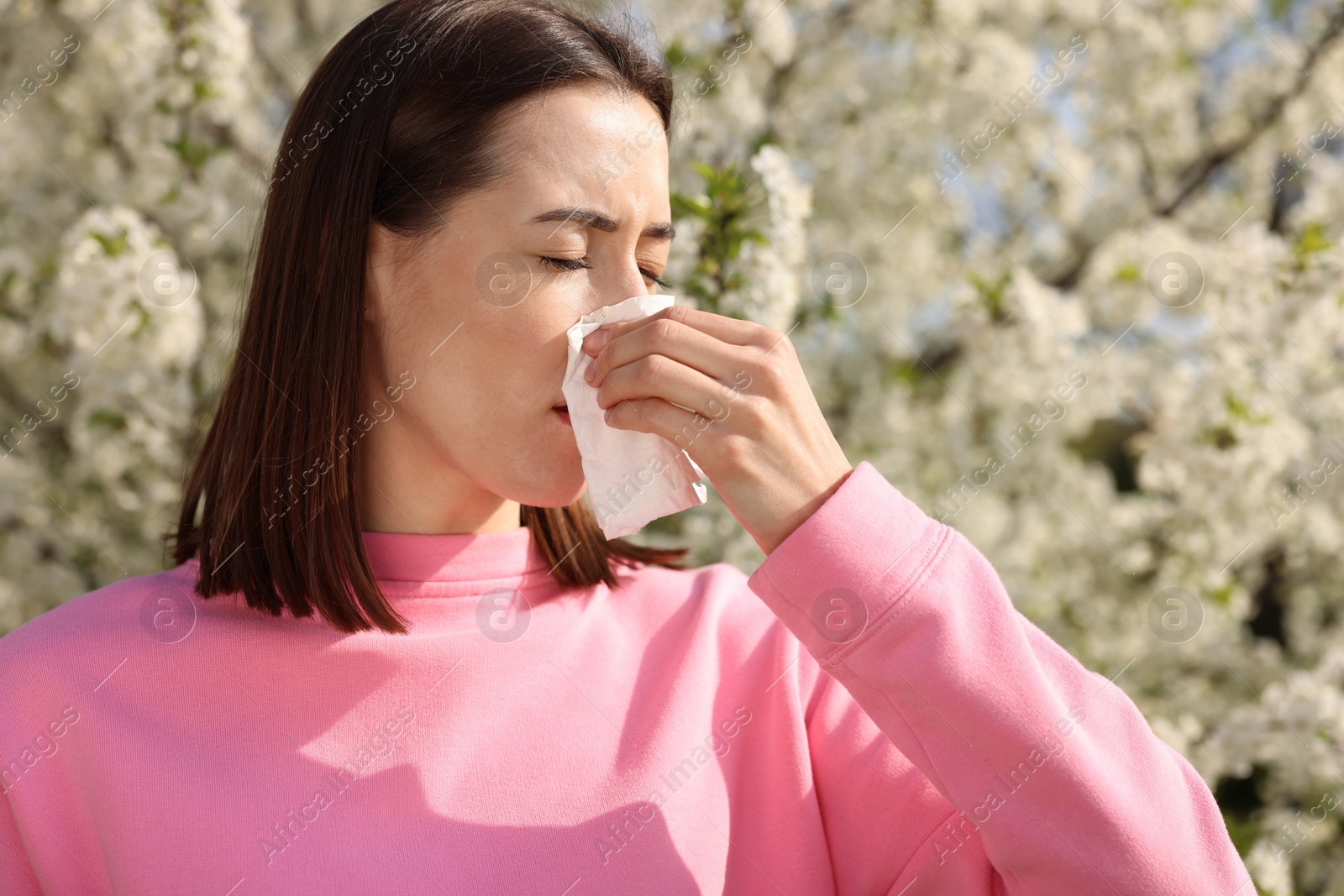 Photo of Woman with napkin suffering from seasonal allergy on spring day