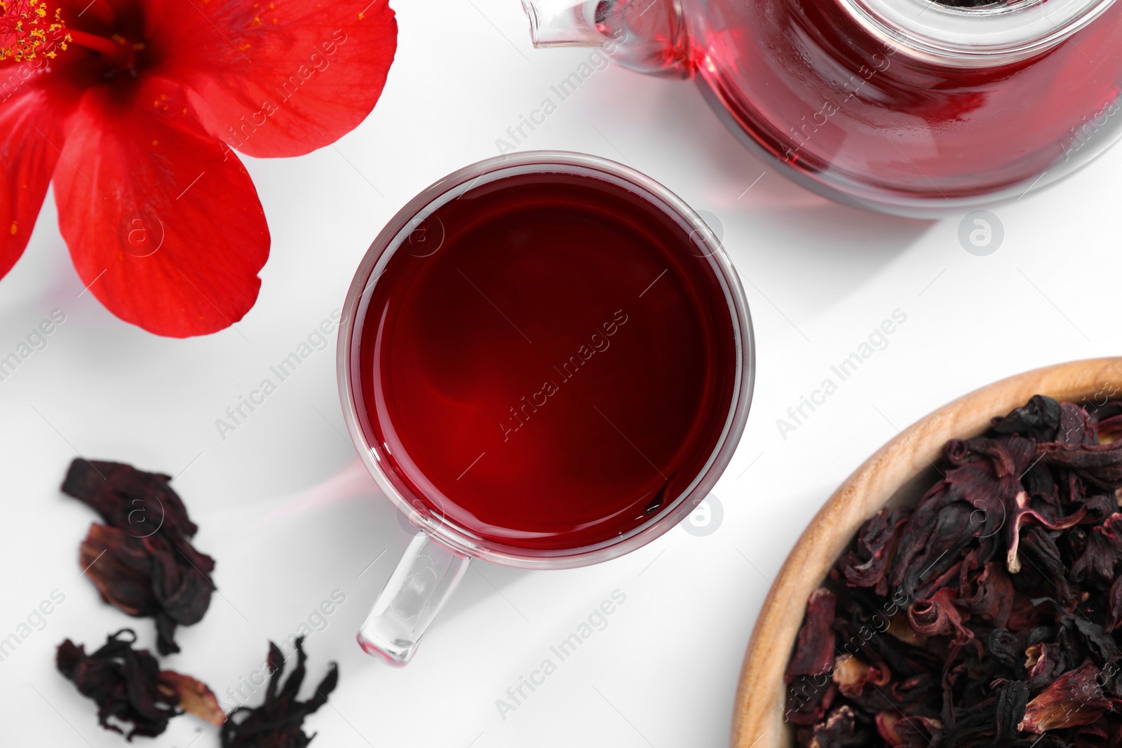 Photo of Delicious hibiscus tea and flowers on white background, flat lay
