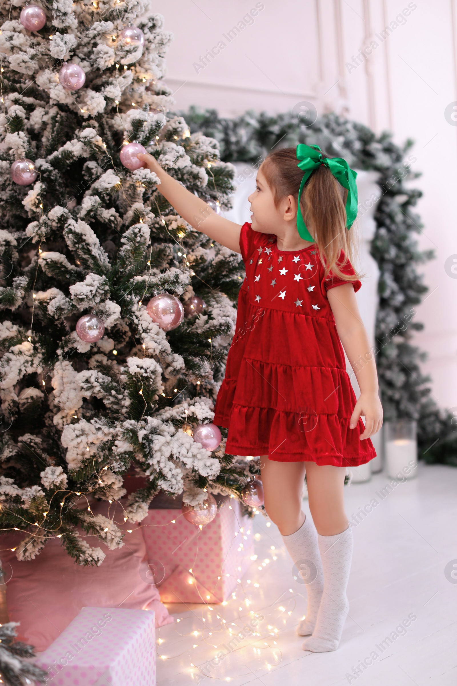 Photo of Cute little child near Christmas tree at home