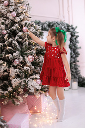 Cute little child near Christmas tree at home