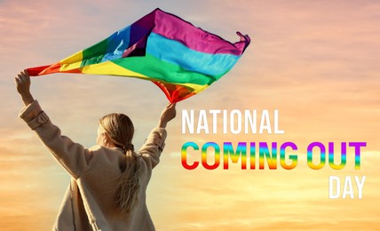 Image of National Coming Out day. Woman holding bright LGBT flag against sky, back view