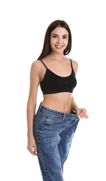 Photo of Attractive young woman with slim body wearing her old big jeans on white background