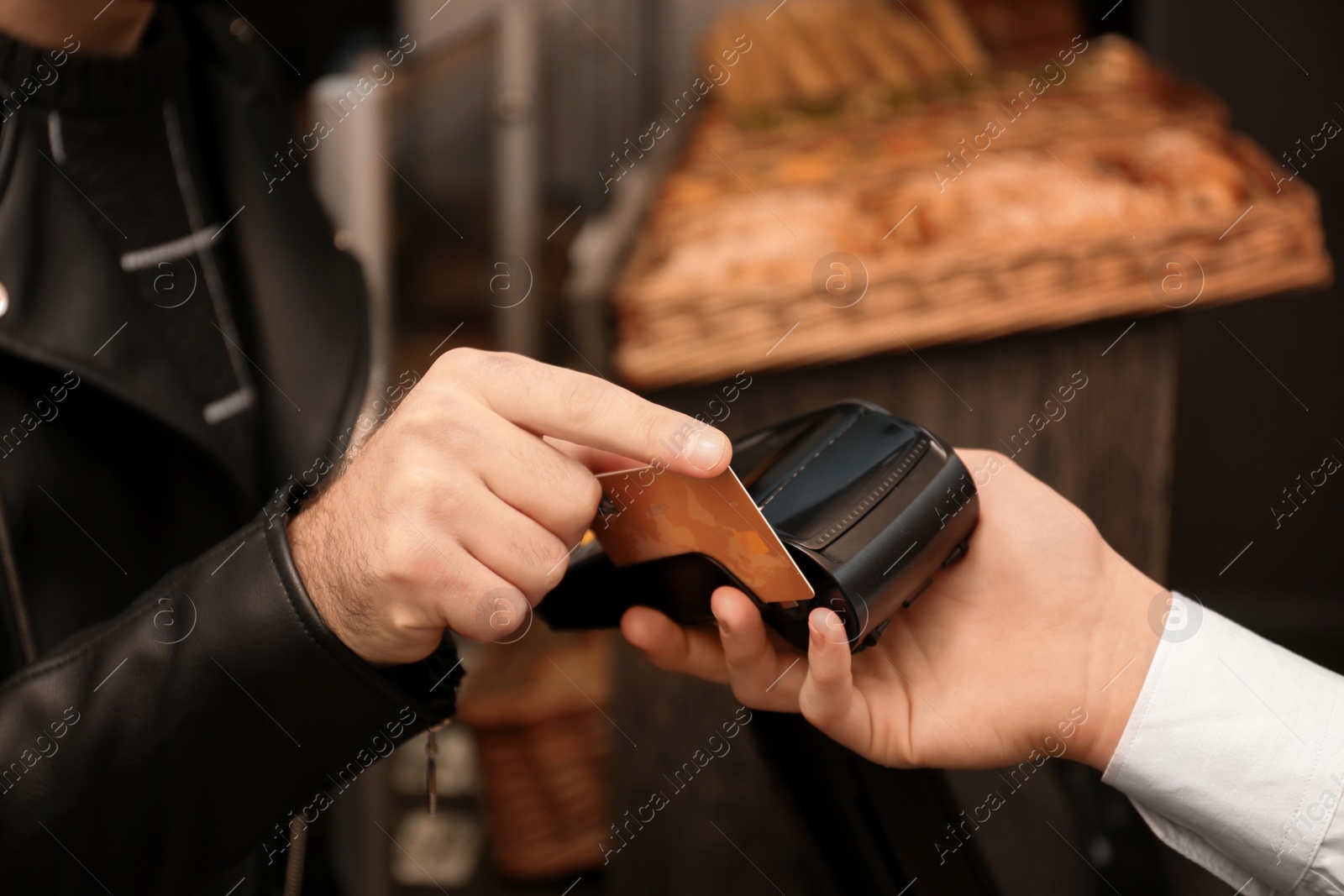 Photo of Man with credit card using payment terminal at shop, closeup