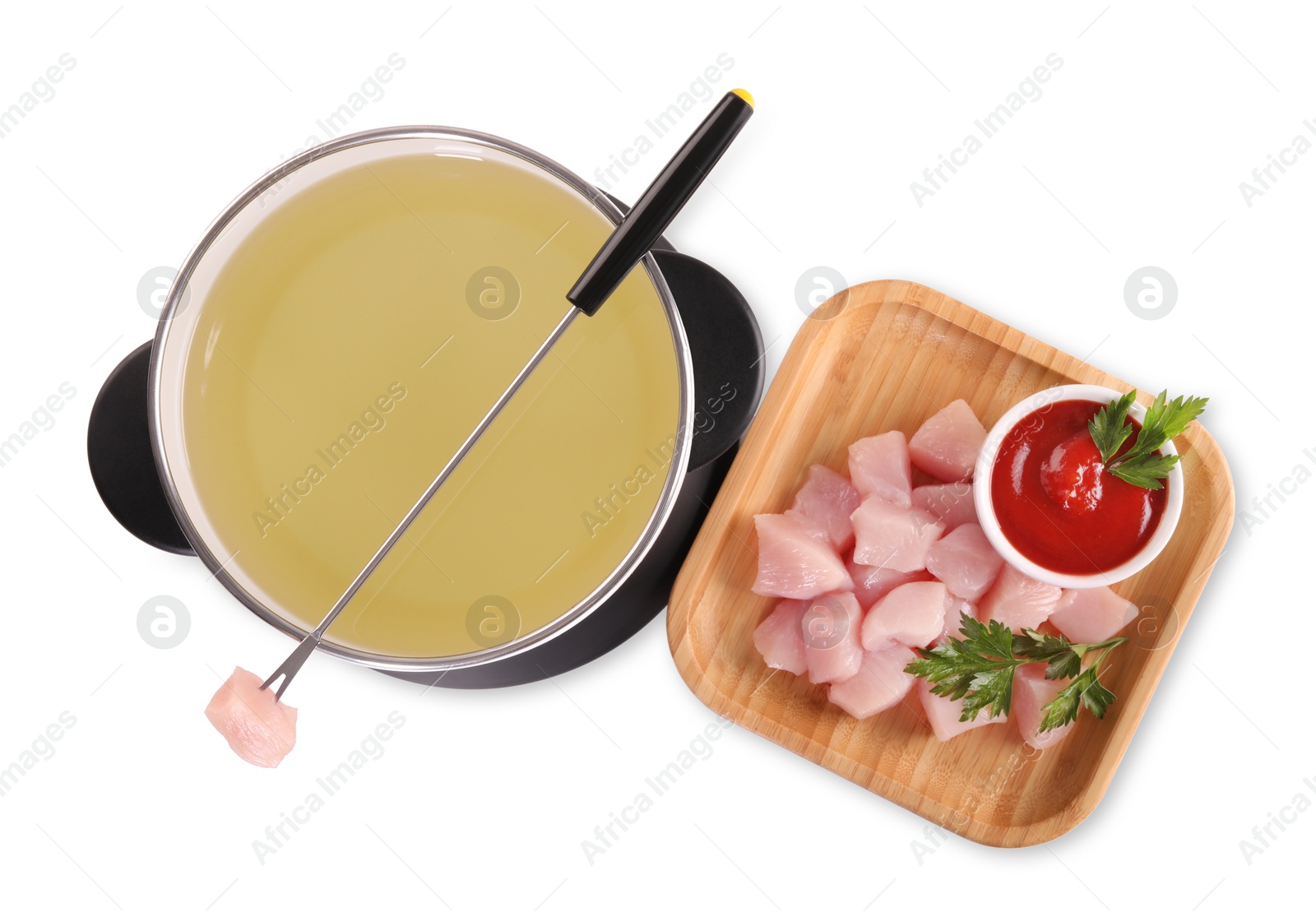 Photo of Oil in fondue pot, fork, pieces of raw meat and sauce isolated on white, top view