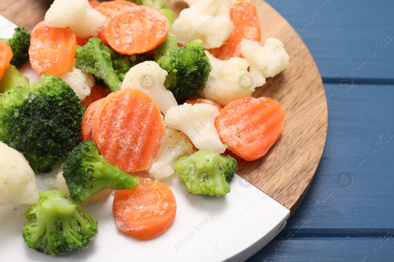 Photo of Mix of different frozen vegetables on blue wooden table, closeup