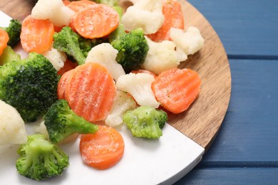 Photo of Mix of different frozen vegetables on blue wooden table, closeup