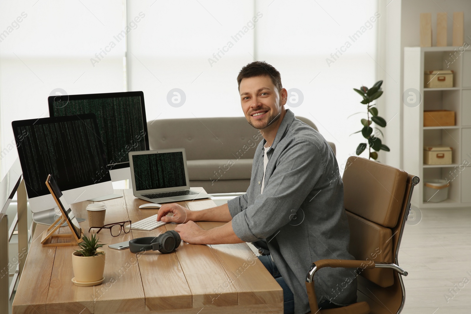 Photo of Happy programmer working at desk in office