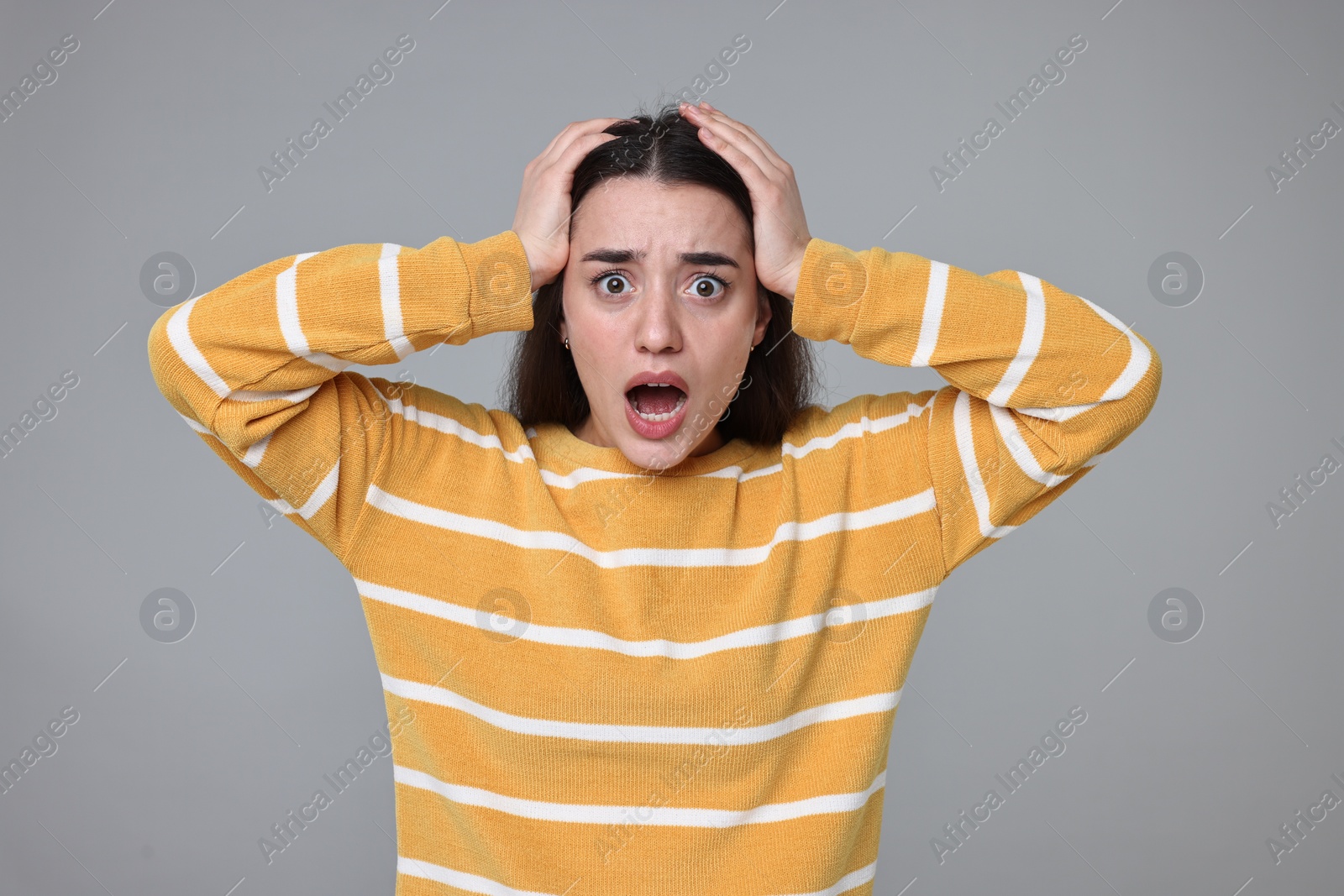 Photo of Portrait of surprised woman on grey background