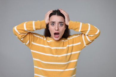 Photo of Portrait of surprised woman on grey background