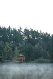 Photo of Beautiful landscape with forest and house near lake. Summer camp location