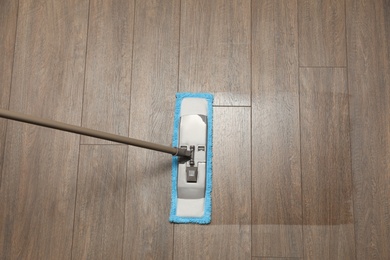 Photo of Cleaning of wooden floor with mop, above view