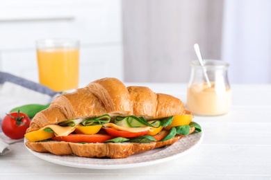 Tasty vegetarian croissant sandwich on white table