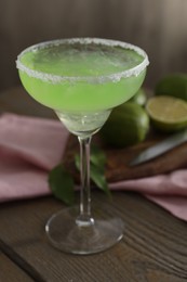 Photo of Delicious Margarita cocktail in glass on wooden table, closeup