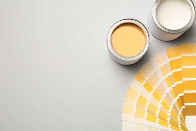 Paint cans and color palette on white background, top view. Space for text