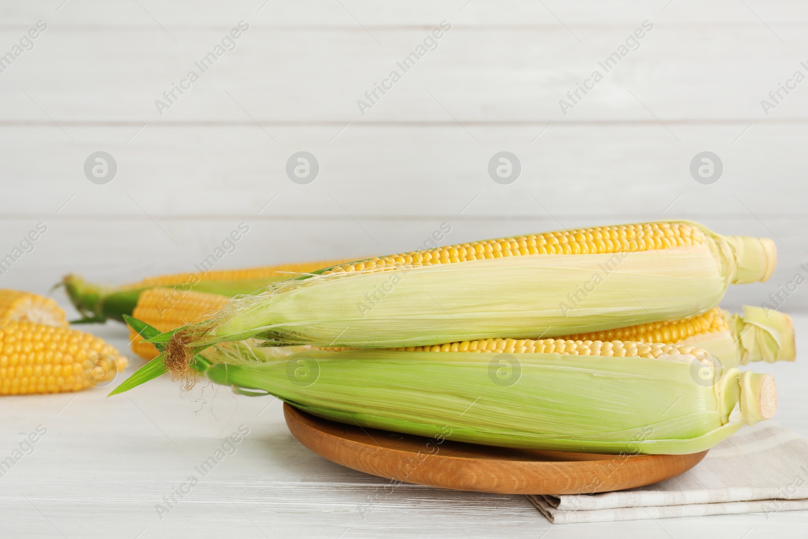 Photo of Plate with tasty sweet corn cobs on table