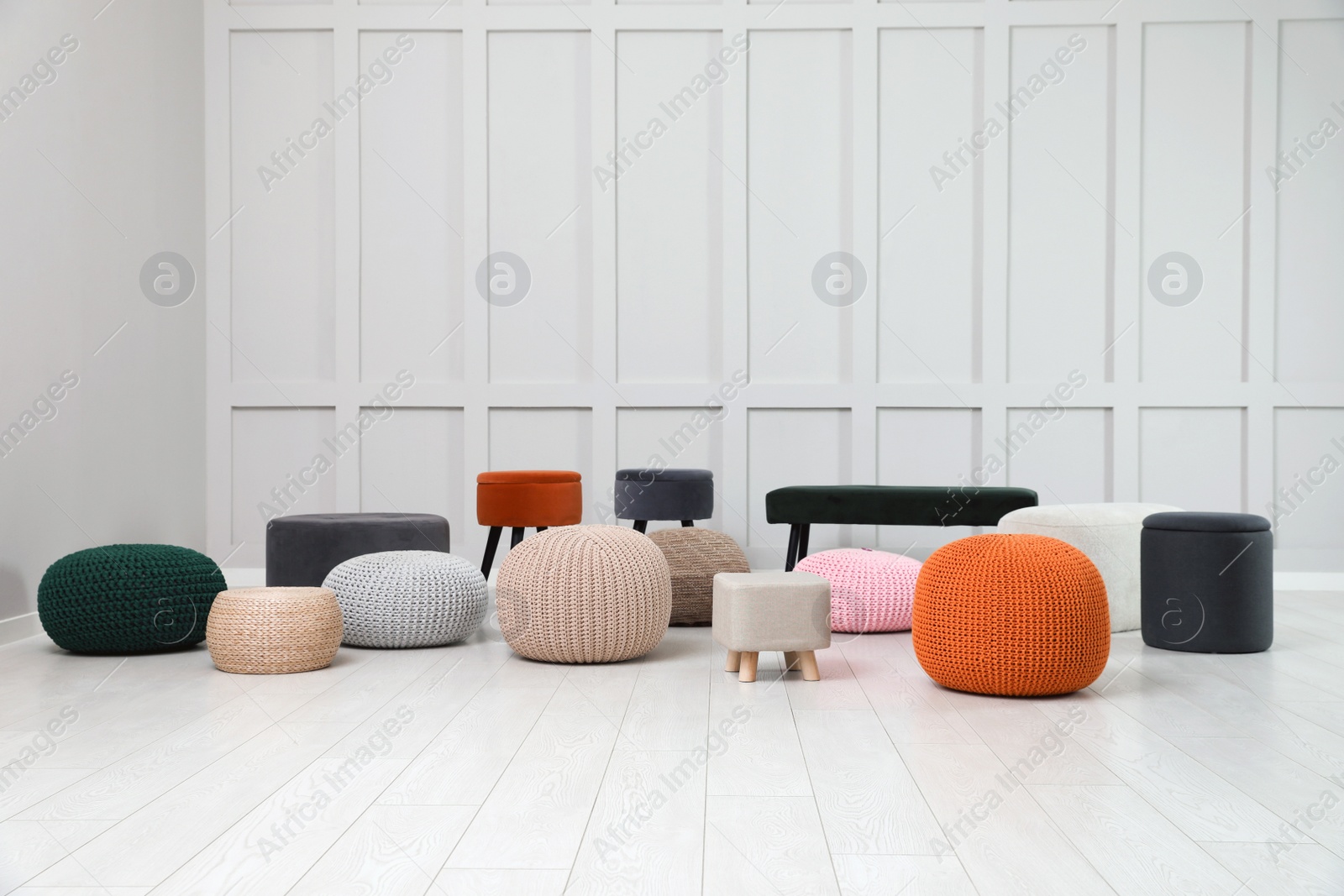 Photo of Different stylish poufs and ottomans in room