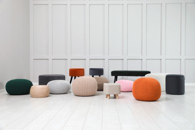 Different stylish poufs and ottomans in room