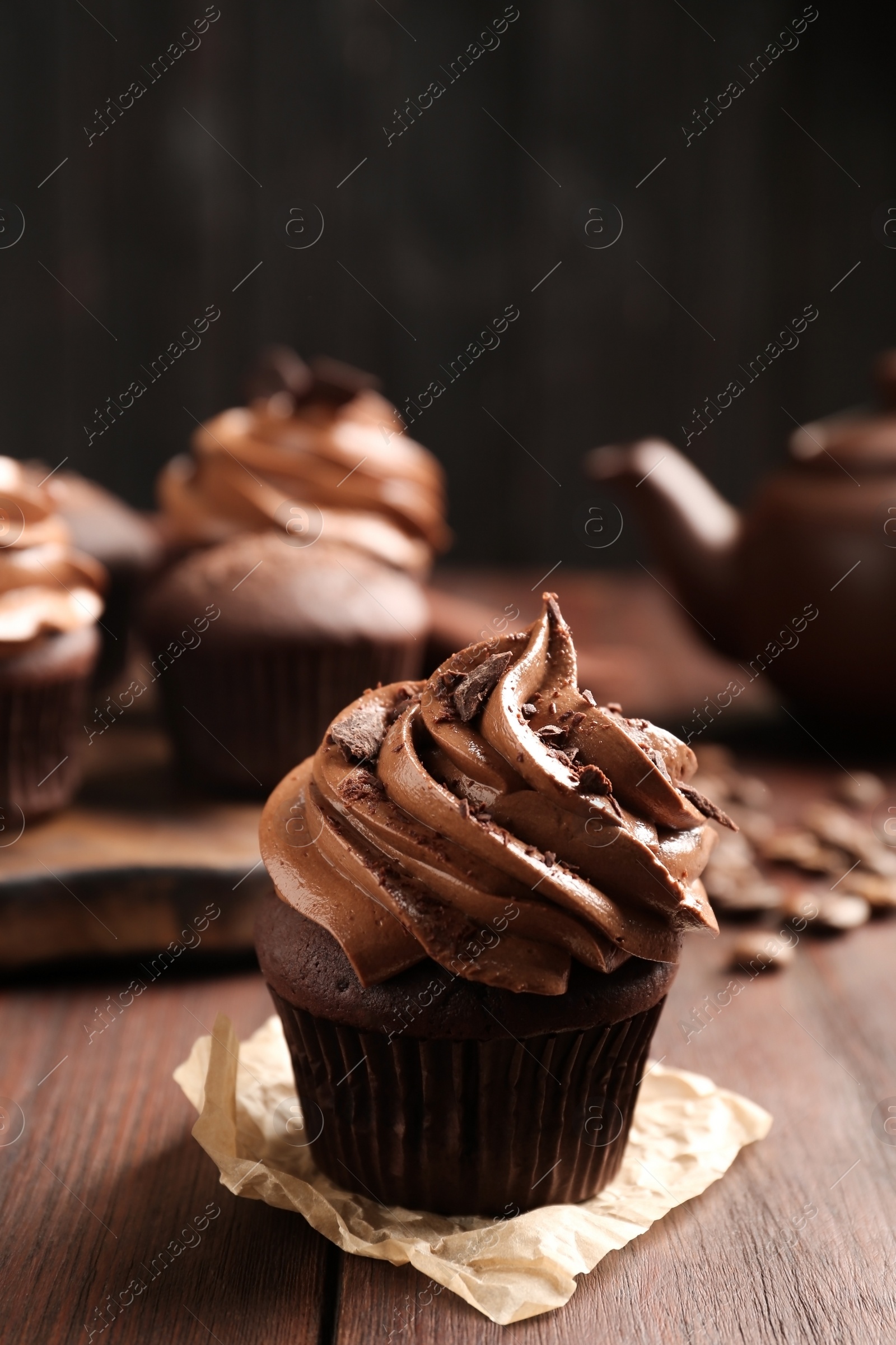 Photo of Delicious cupcake decorated with cream on wooden table