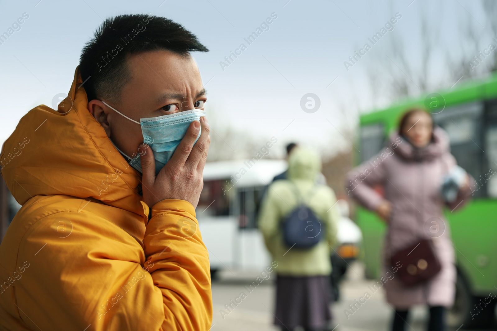 Photo of Asian man wearing medical mask on city street, space for text. Virus outbreak