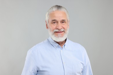Portrait of handsome senior man on light grey background
