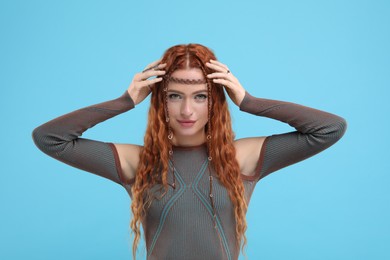 Photo of Beautiful young hippie woman on light blue background