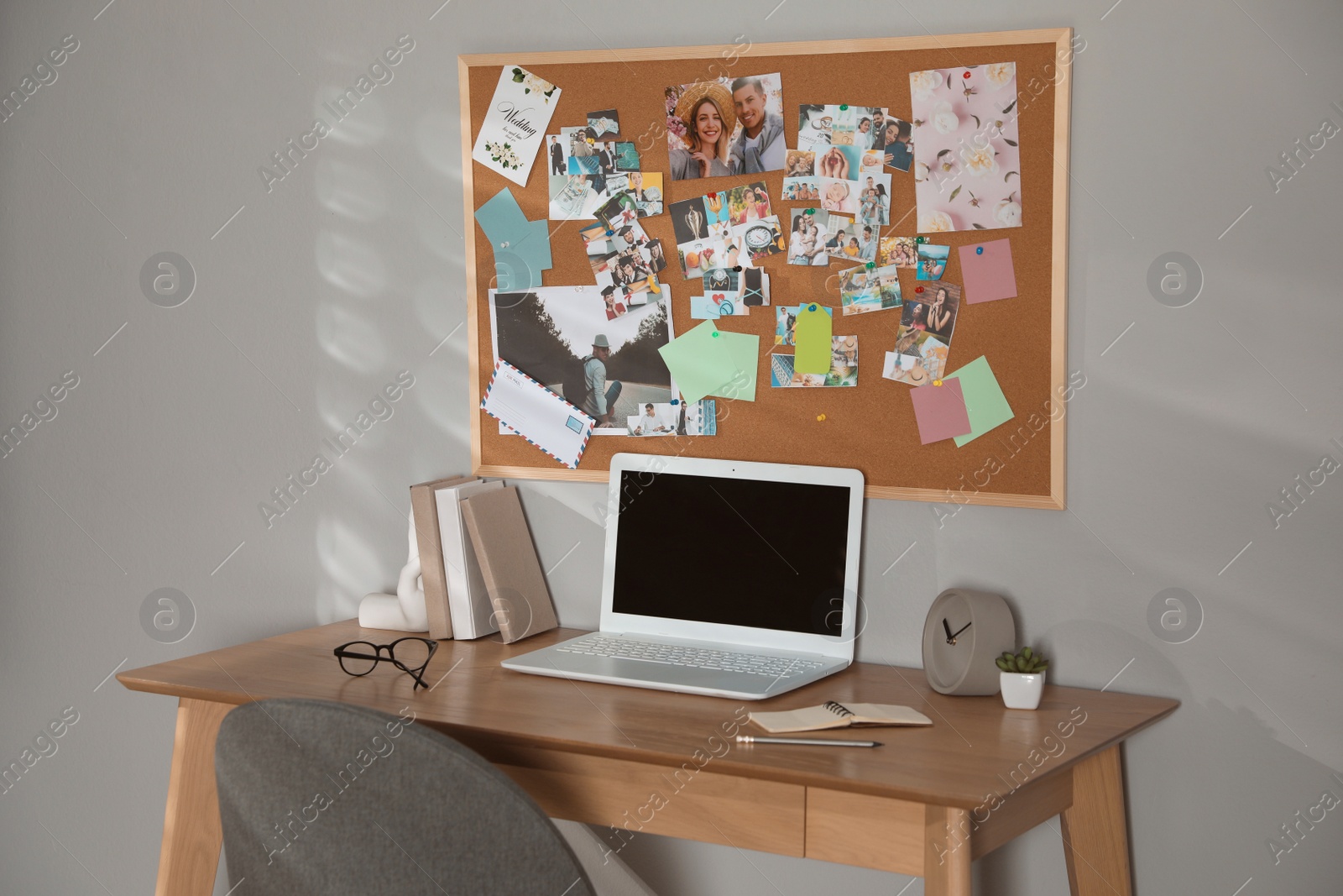 Photo of Stylish workplace with vision board and laptop