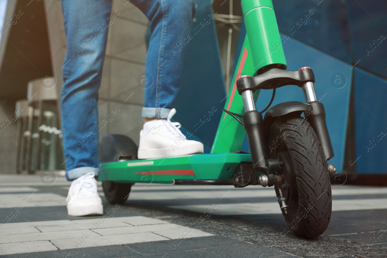 Photo of Woman with modern electric kick scooter outdoors, closeup