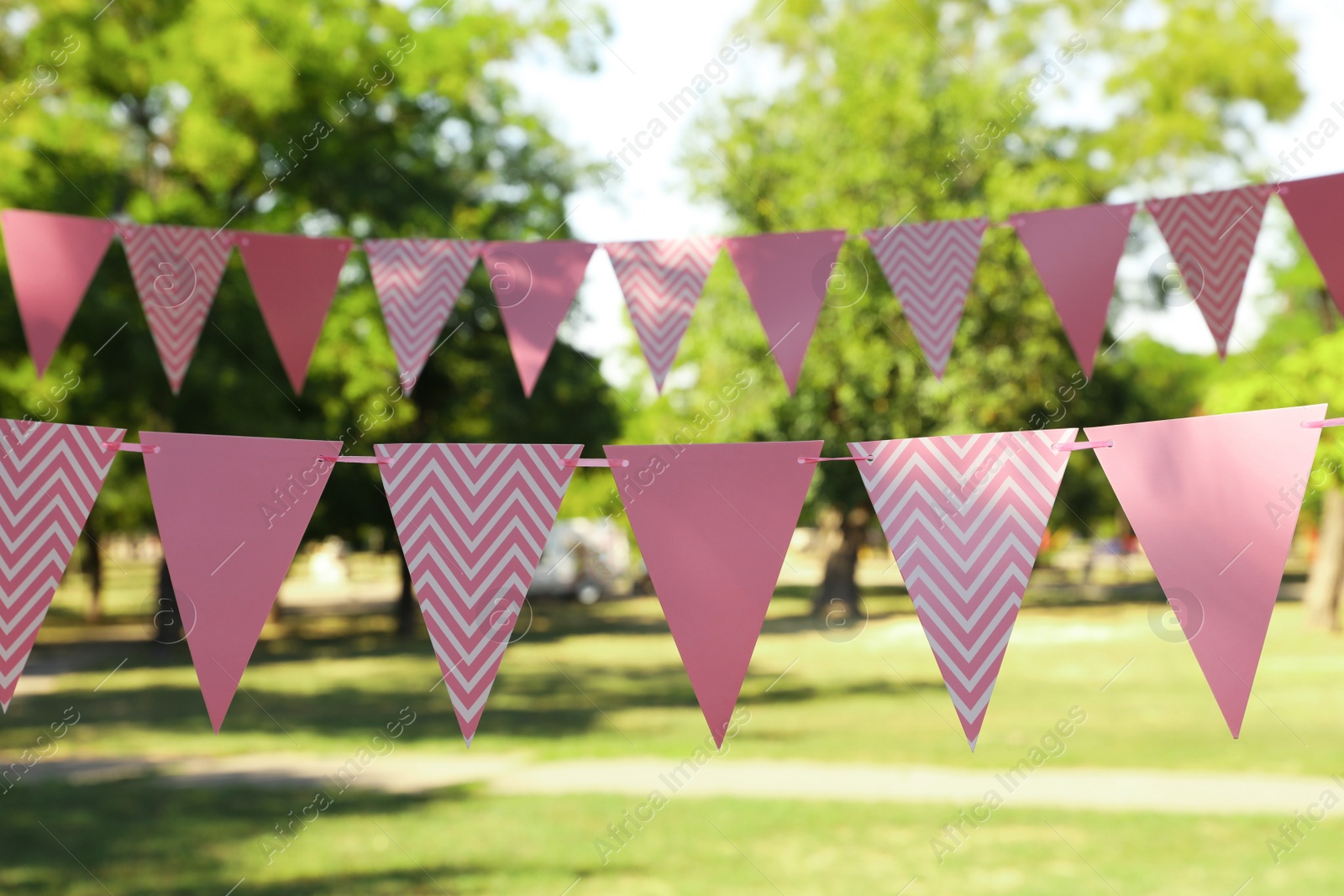 Photo of Pink bunting flags in park. Party decor