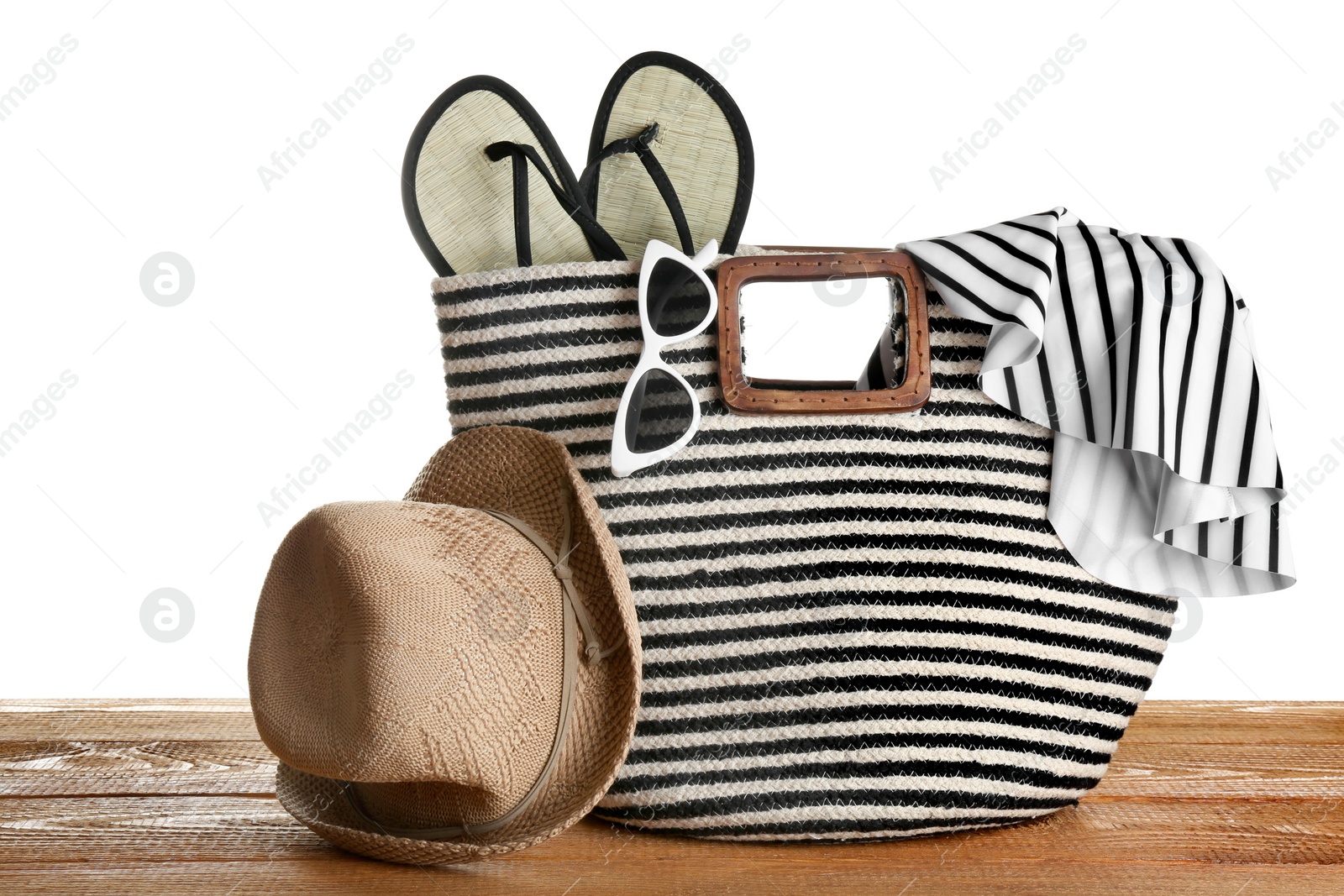 Photo of Set of beach accessories on wooden table, white background