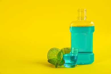 Photo of Mouthwash, fresh mint and lime on yellow background. Space for text