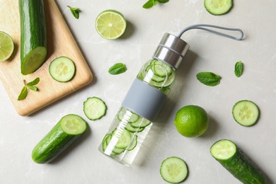 Flat lay composition with bottle of fresh  cucumber water on grey background