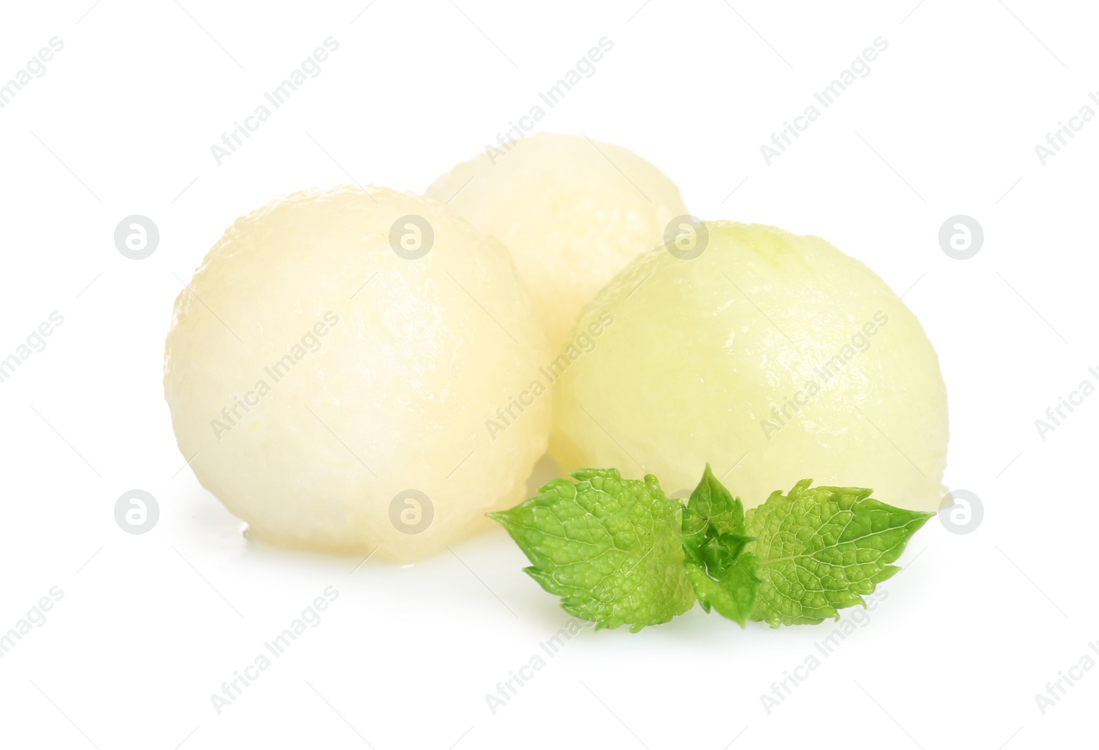 Photo of Juicy sweet melon balls with mint on white background