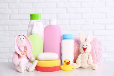 Baby accessories on table near white brick wall