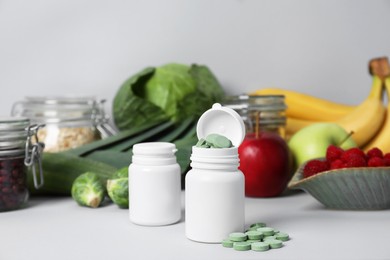 Photo of Bottles of prebiotic pills and food on grey table