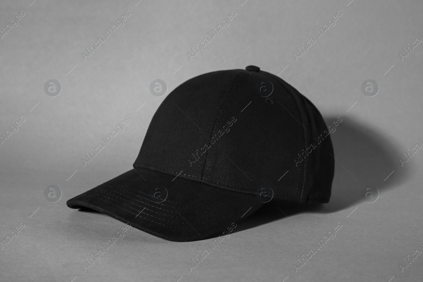 Photo of Stylish black baseball cap on grey background