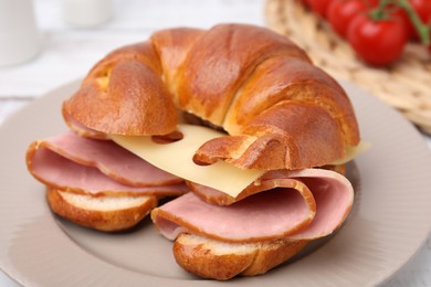 Photo of Tasty crescent roll with ham and cheese on table, closeup