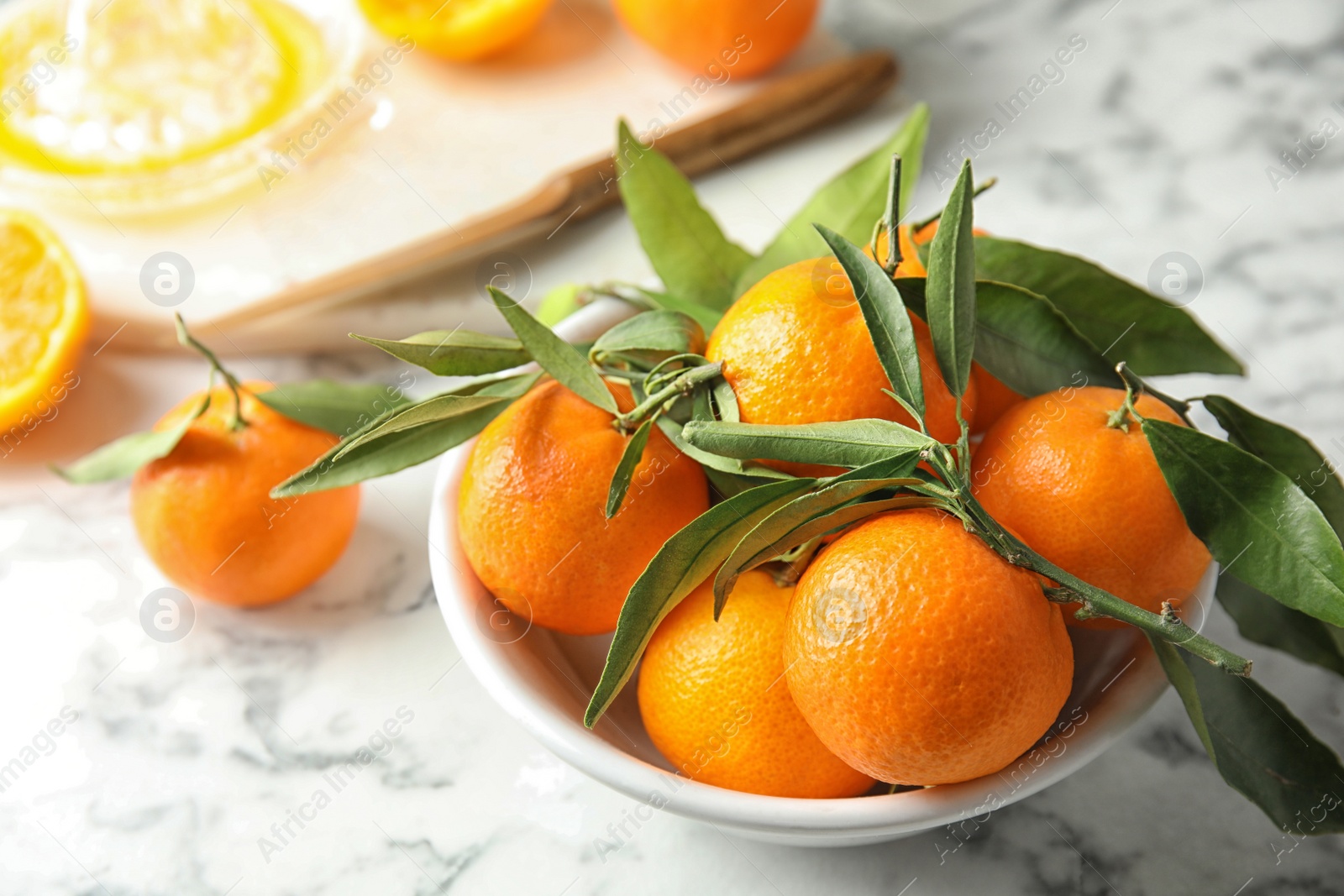 Photo of Bowl with ripe tangerines on table. Citrus fruit